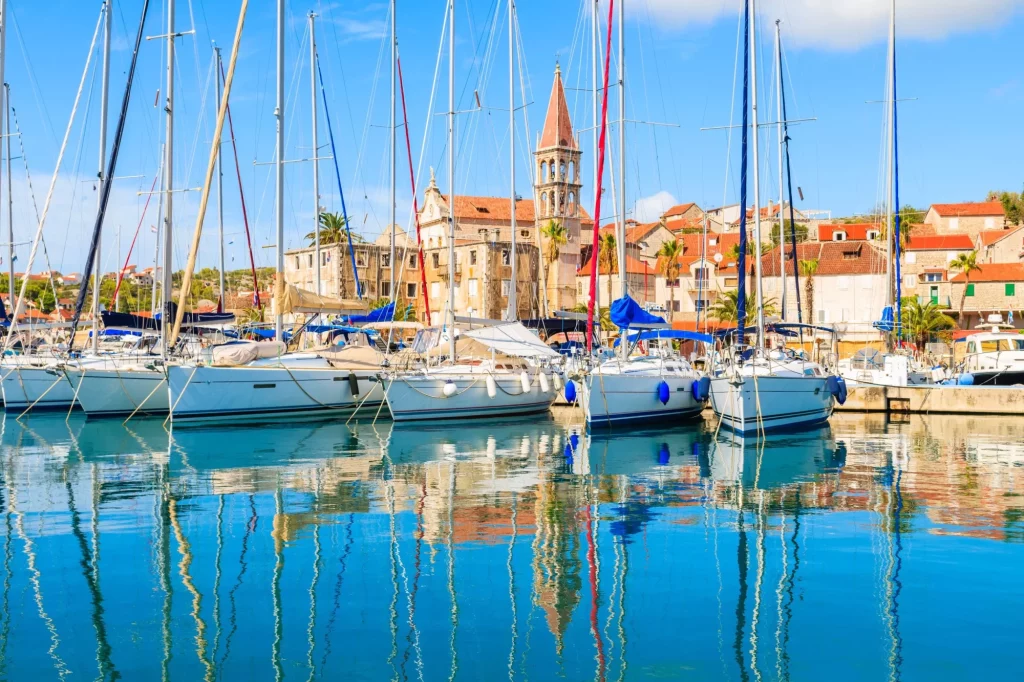 Reflection of sailing boats anchoring in beautiful milna port with church tower in background brac island croatia stockpack adobe stock Reflection of sailing boats anchoring in beautiful Milna port with church tower in background, Brac island, Croatia